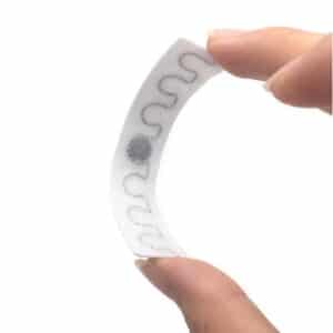 fingers bending a flexible rfid UHF laundry tag